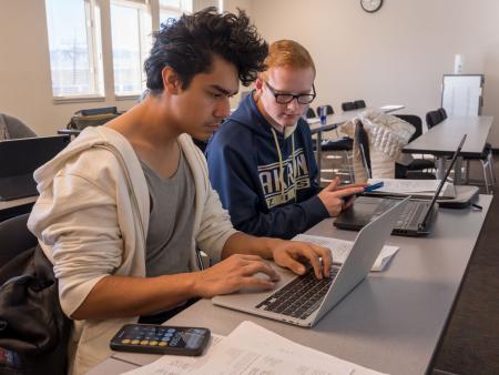 ACC accounting students in classroom working together at laptop at the Littleton Campus.