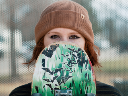 Photo of a woman holding a skateboard by Luke Schott