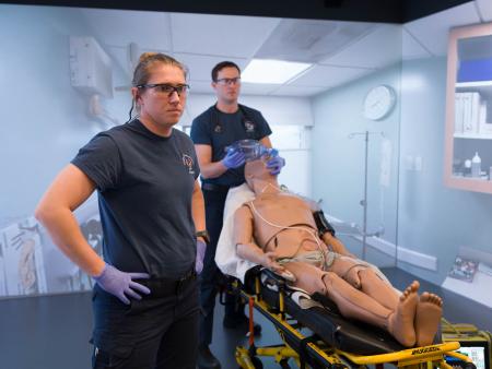 Two ACC EMS/Paramedic students working with manikin on a gurney in new facilities at the Littleton Campus.