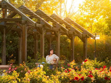 Photo of a woman surrounded by flowers by Sally Grant