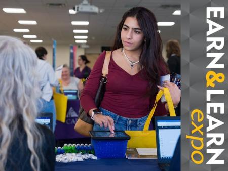 Earn & Learn Expo - ACC student at event talking to person at a table