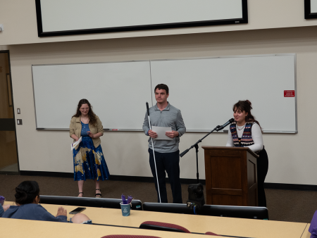 3 ACC students participating in a speech competition - standing in front of a classroom at the Littleton Campus.
