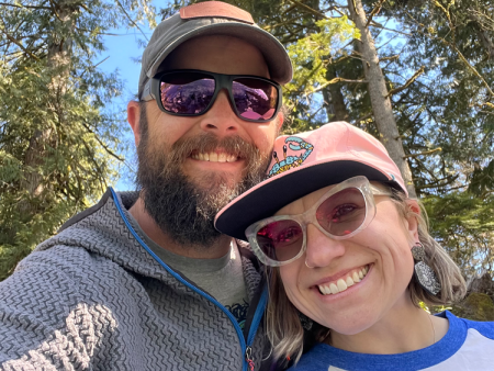 Grace Crain-Wright with husband Sam in front of trees.