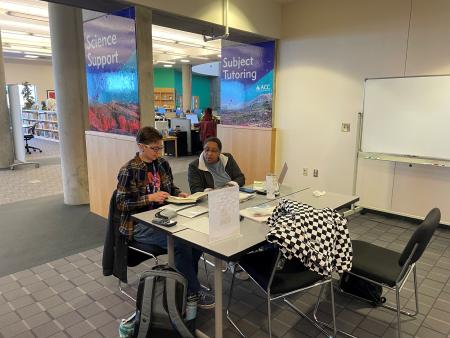 ACC peer mentor in the Peer Academic Mentor Program assisting another student in the Tutoring & Learning Resources Center in the Library at the Littleton Campus.