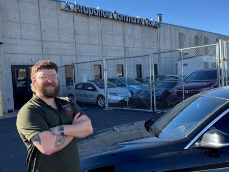 Arapahoe Community College (ACC) alumnus Daniel Girolamo standing in front of ACC's Automotive Technology school