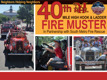 Firetrucks and response vehicles in a parade in downtown Littleton, Colorado. Child seated in driver's seat of fire truck. 