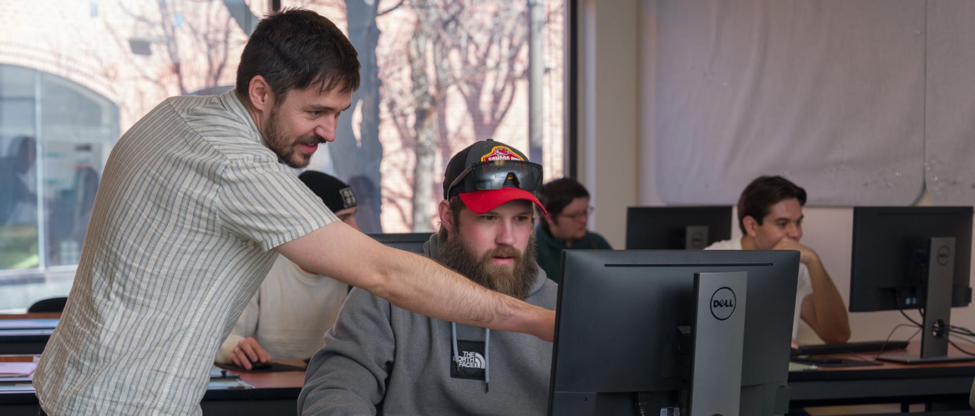 ACC Architecture faculty member helping a student using CAD software in the Art and Design Center at ACC's Littleton Campus.