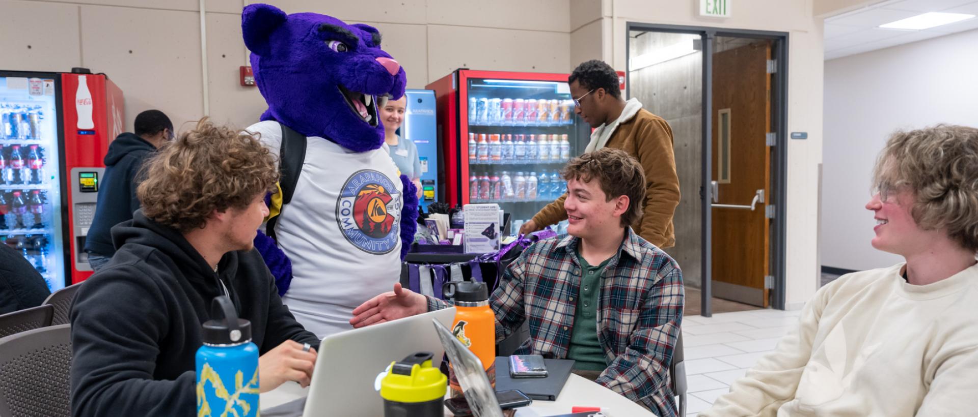 ACC students with mascot Summit in the student lounge in the main building at the Littleton Campus.