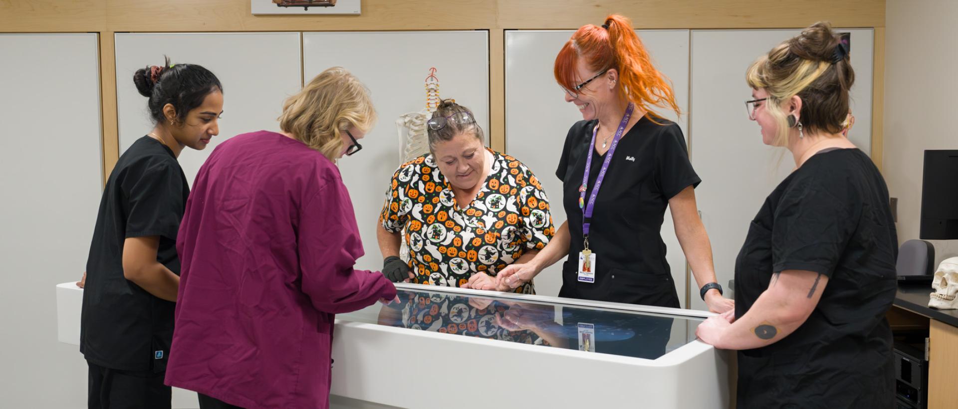 ACC students and faculty in a physical therapy class at the Sturm Collaboration Campus in Castle Rock, using the anatomage table.