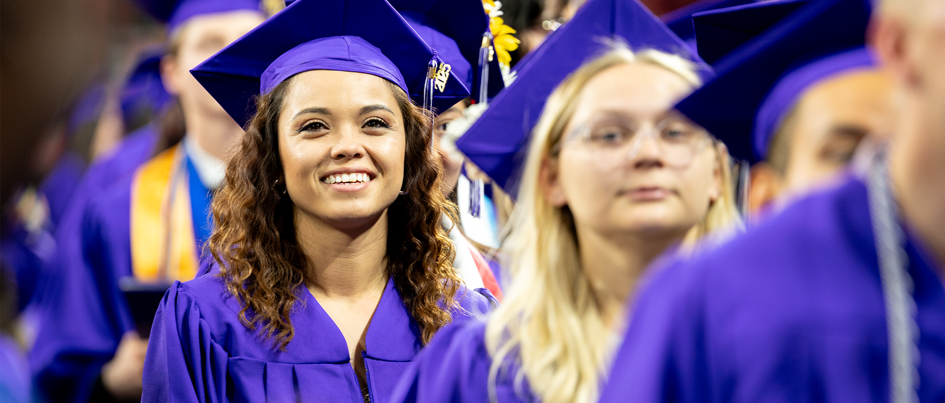 ACC graduates at commencement in purple regalia.