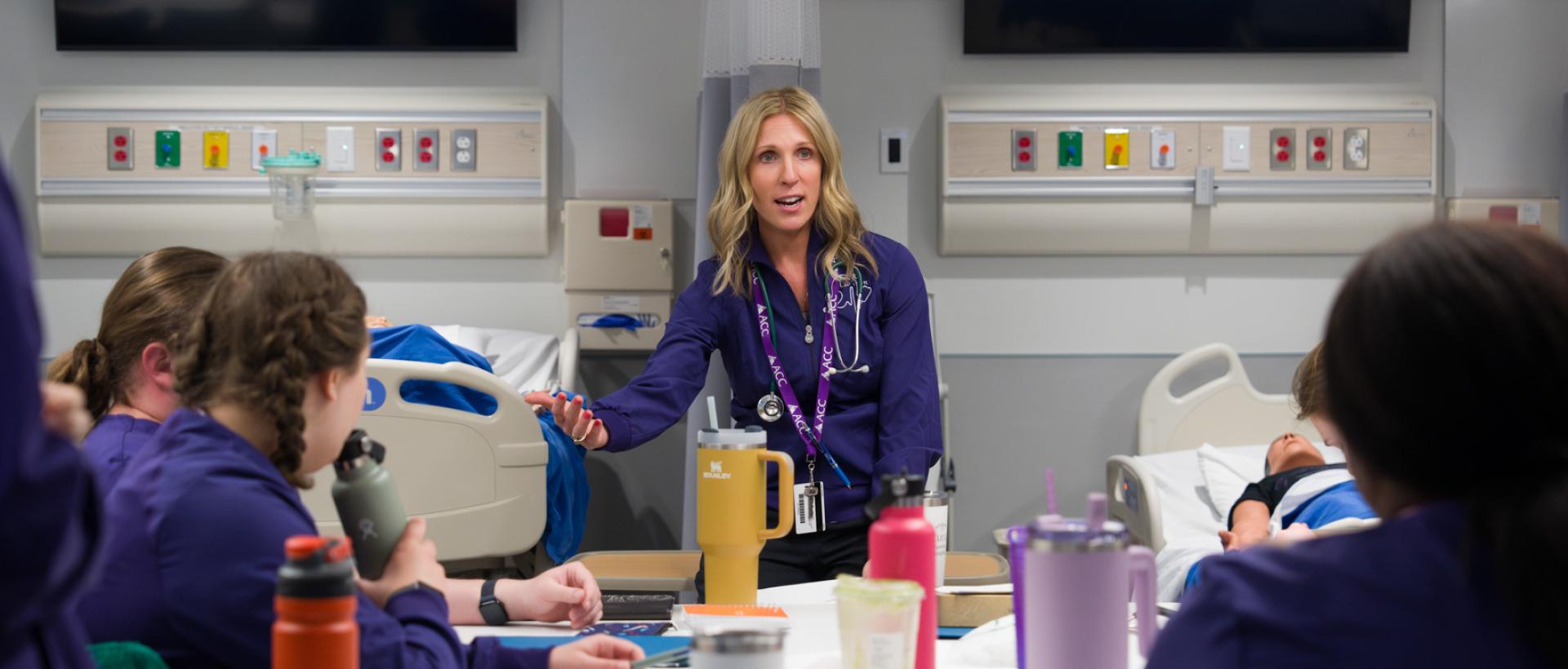 Nursing instructor in front of class in interactive nursing classroom in the Health Innovation Center at ACC's Littleton Campus