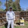 Luke Curtis, ACC Beekeeping student in beekeeper gear in front of beehive.