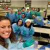 ACC Medical Assisting Apprentices in scrubs and gloves, pose for a picture during class.