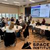 Participants at ACC's Space Educator Bootcamp sitting at tables and viewing presentation.