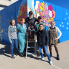ACC students stand in front of completed mural: Roots of Learning, Wings of Growth, at the Littleton Campus.