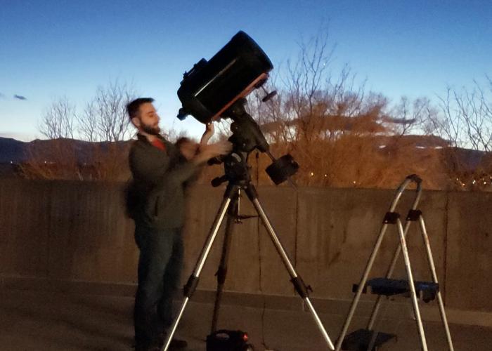 ACC student with telescopes in a field looking toward the sky at dusk.