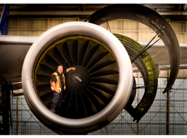 Airline worker in front of airplane engine (photo by Peggy Tio)