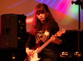 ACC student playing guitar in pop/rock concert at the Littleton Campus.