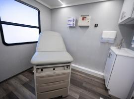 ACC Mobile Learning Lab interior exam room with exam table, cabinets, window.