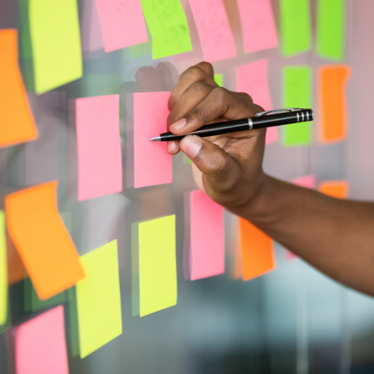 person writing on sticky notes on wall
