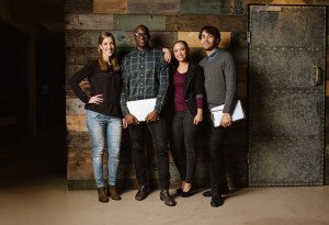 Portrait of successful business team standing together against wooden wall. Full length image of a group of diverse colleagues standing in an office