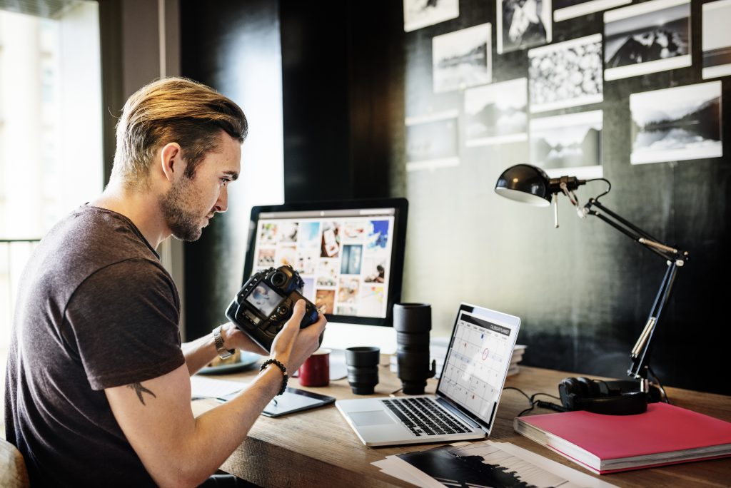 Photographer with camera and computers